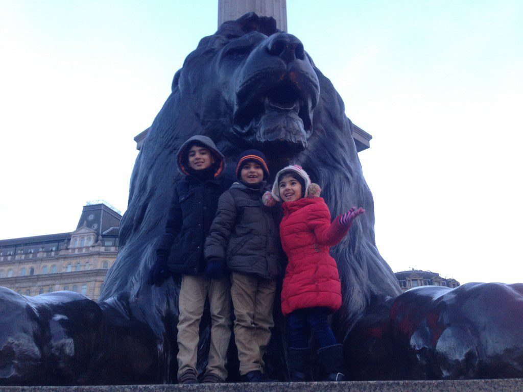 In front of a lion statue in Trafalgar Square