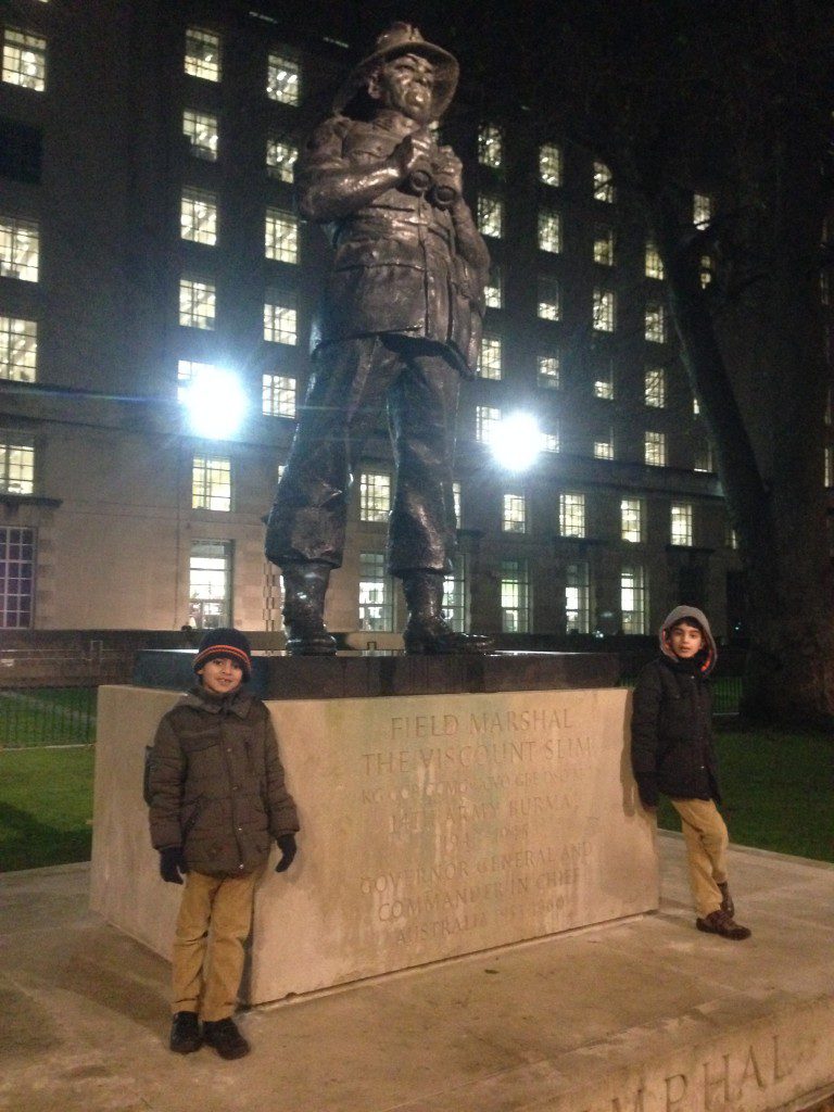 In front of a war memorial (a statue of Field Marshal The Viscount Slim)